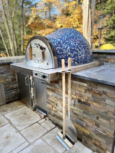 Backyard entertainment space with HPC Fire Villa Series built-in outdoor pizza oven and stone kitchen